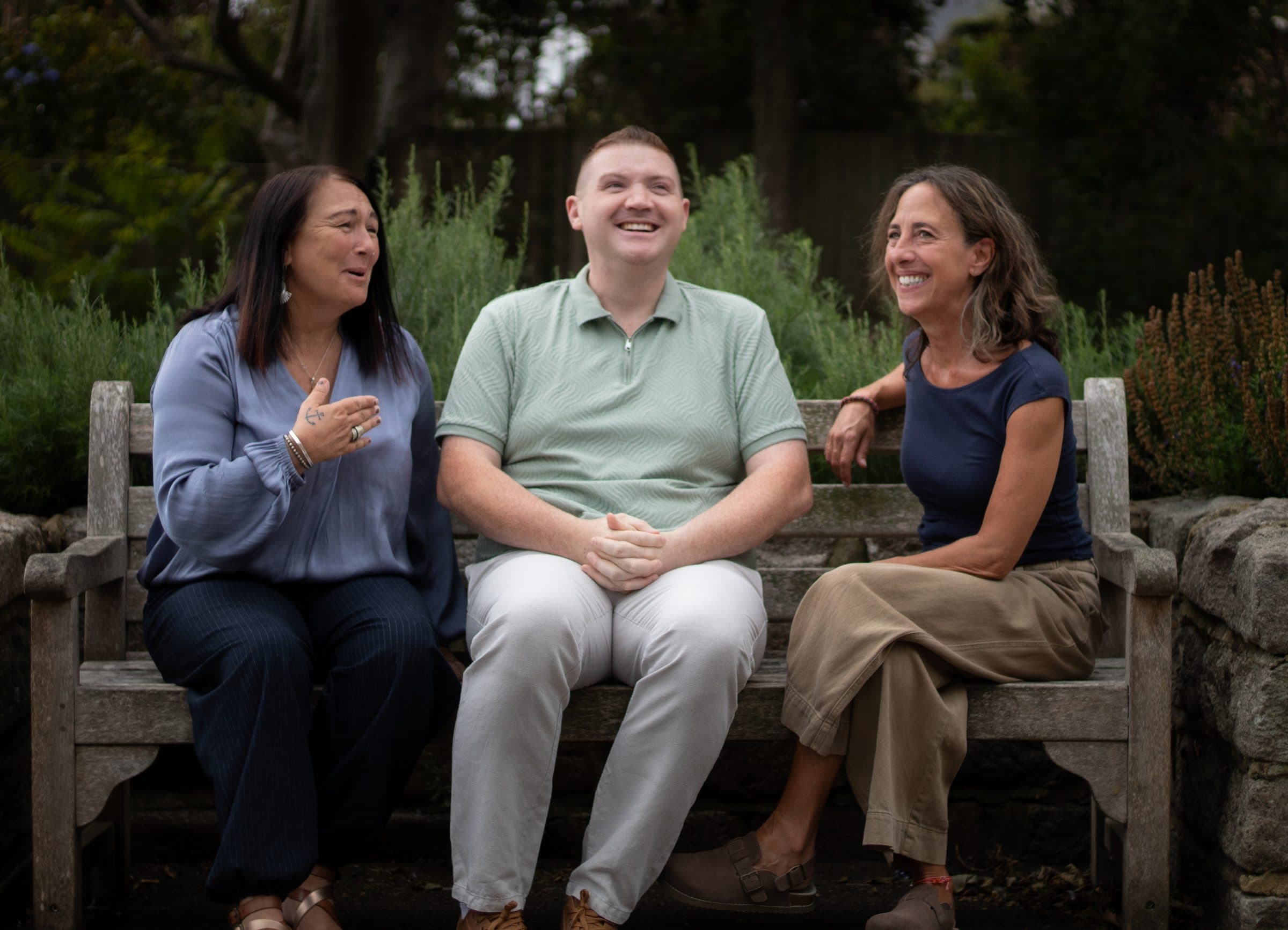 Adam, Michela and Jane sitting together on a garden bench